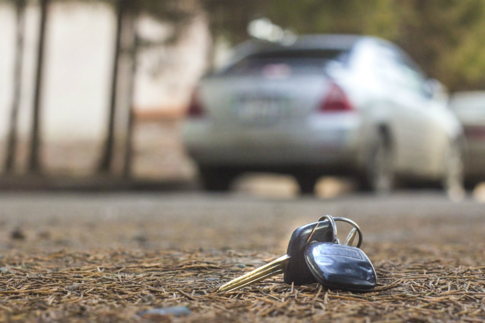 A key in the dirt with a car in the background